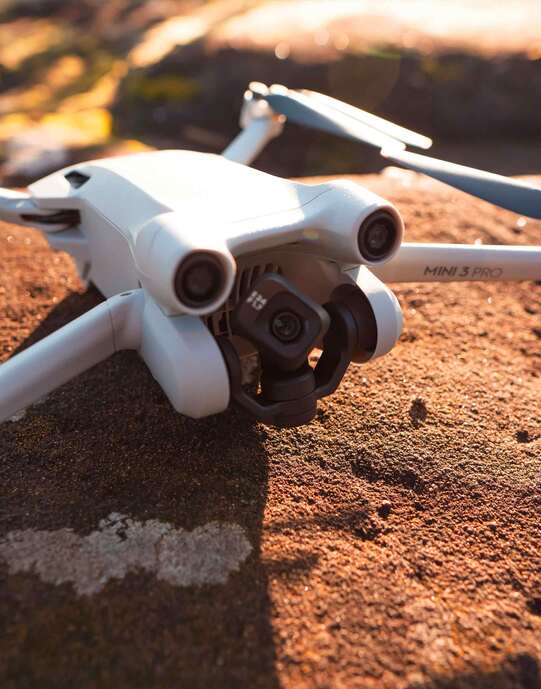 Photo d'un studio audio avec le logiciel Ableton live, un push, une tasse, une enceinte et une guitare en fond